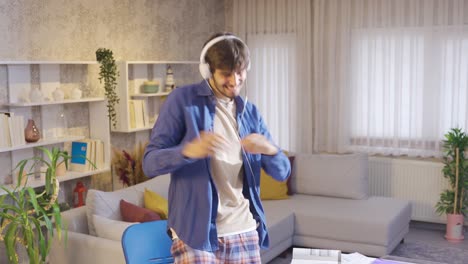 Male-student-looking-at-his-laptop-and-receiving-good-news-dancing-happily-and-having-fun.